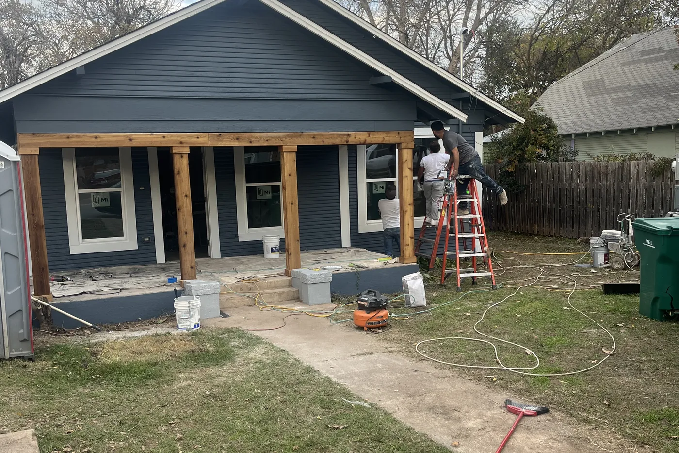 The same 13th Street house with new grey siding and rebuilt cedar porch posts